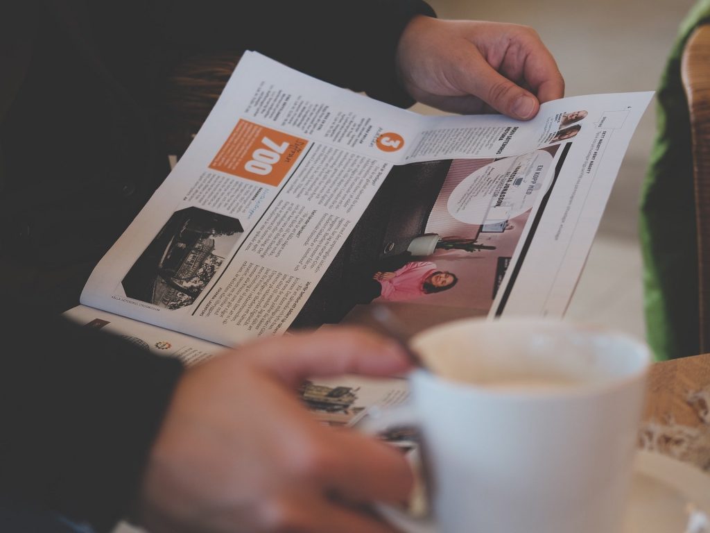 Man Reading Newspaper While Drinking Tea